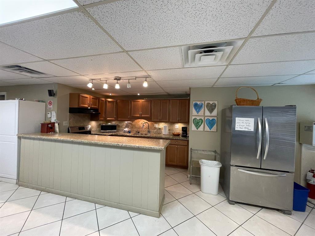 250 Northeast 20th Street, Unit 210 Boca Raton, FL 33431 - Photo 40 of 50 a kitchen with stainless steel appliances granite countertop a refrigerator a stove and a sink