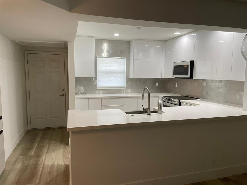250 Northeast 20th Street, Unit 210 Boca Raton, FL 33431 - Photo 9 of 50 a kitchen with stainless steel appliances a sink stove and cabinets