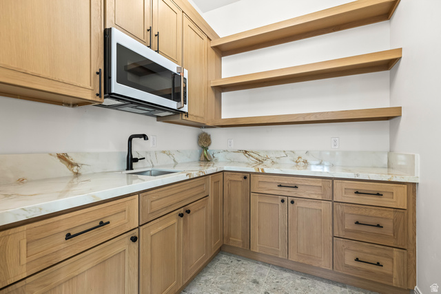 226 East 1100 North Hurricane, UT 84737 - Photo 24 of 49 Kitchen featuring light stone countertops, white microwave, open shelves, and light stone finish flooring