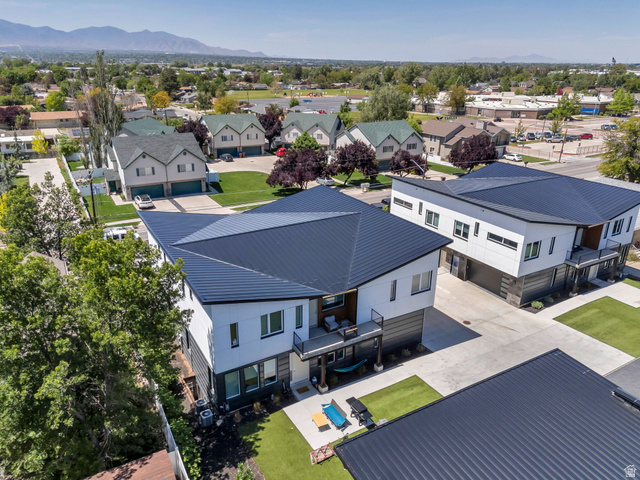 7045 South 300 East Midvale, UT 84047 - Photo 44 of 49 Modern architectural exterior featuring a dark metal roof, white and dark paneling, and a private balcony