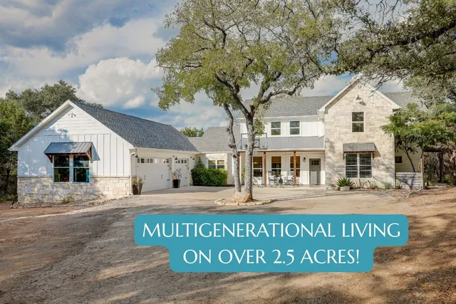 a view of a white house with a large tree