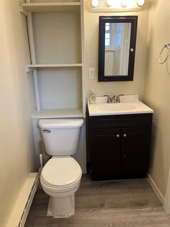 a bathroom with a toilet sink and mirror