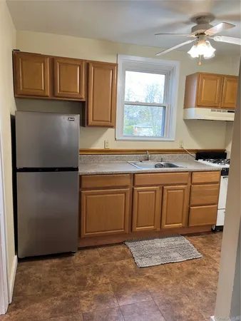 a kitchen with granite countertop a refrigerator a stove a sink and dishwasher