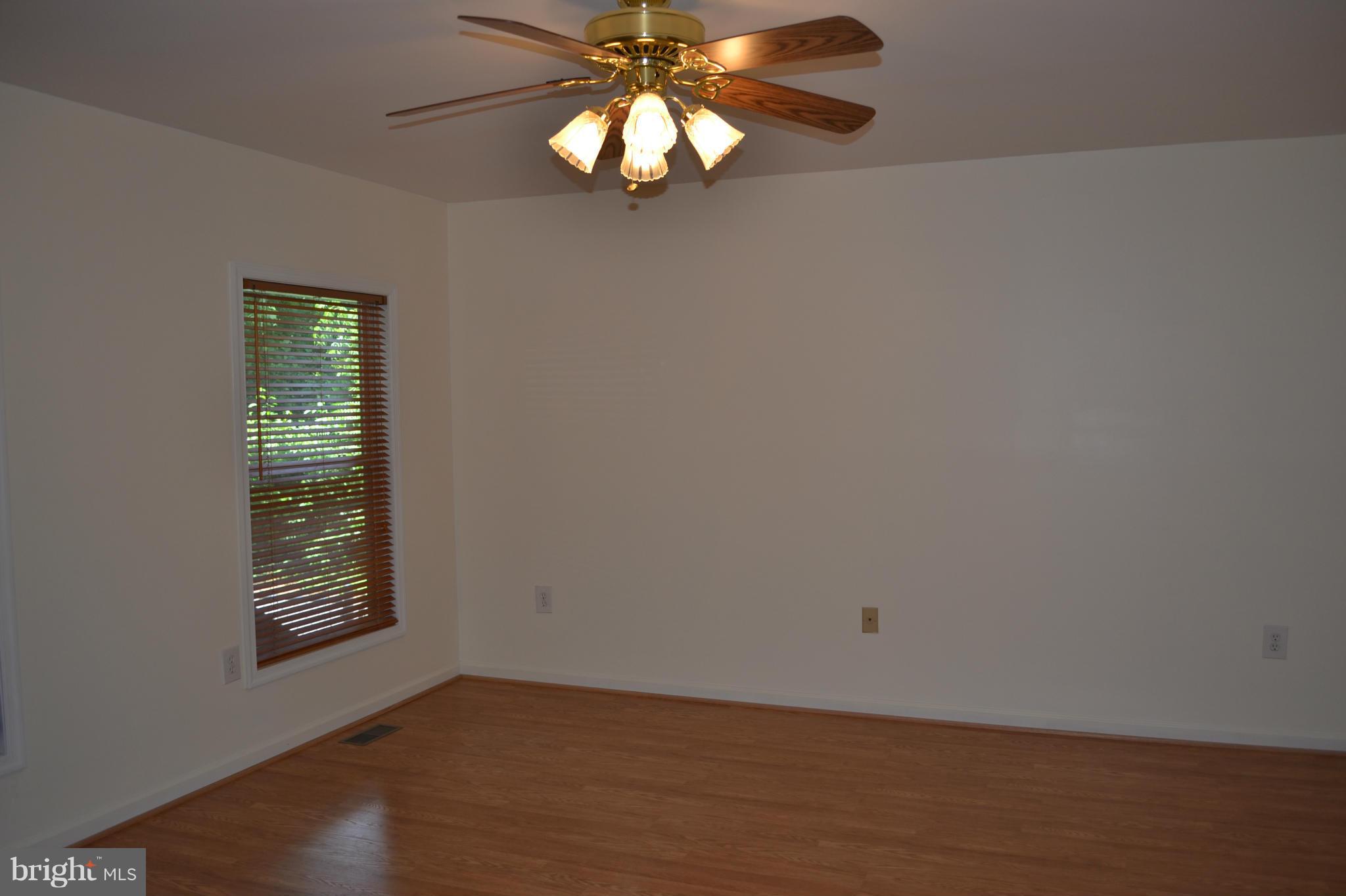 8046 Telegraph Road Severn, MD 21144 - Photo 14 of 27 a view of an empty room with wooden floor and a window