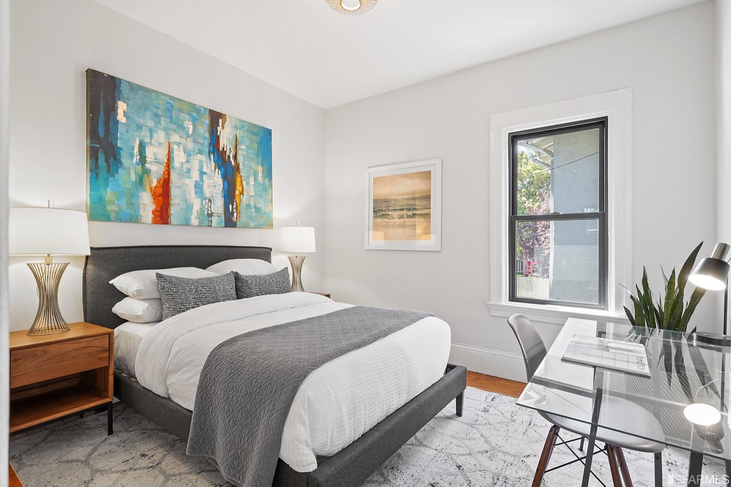 1015 26th Street Oakland, CA 94607 - Photo 16 of 33 a bedroom with a large bed and a painting on the wall