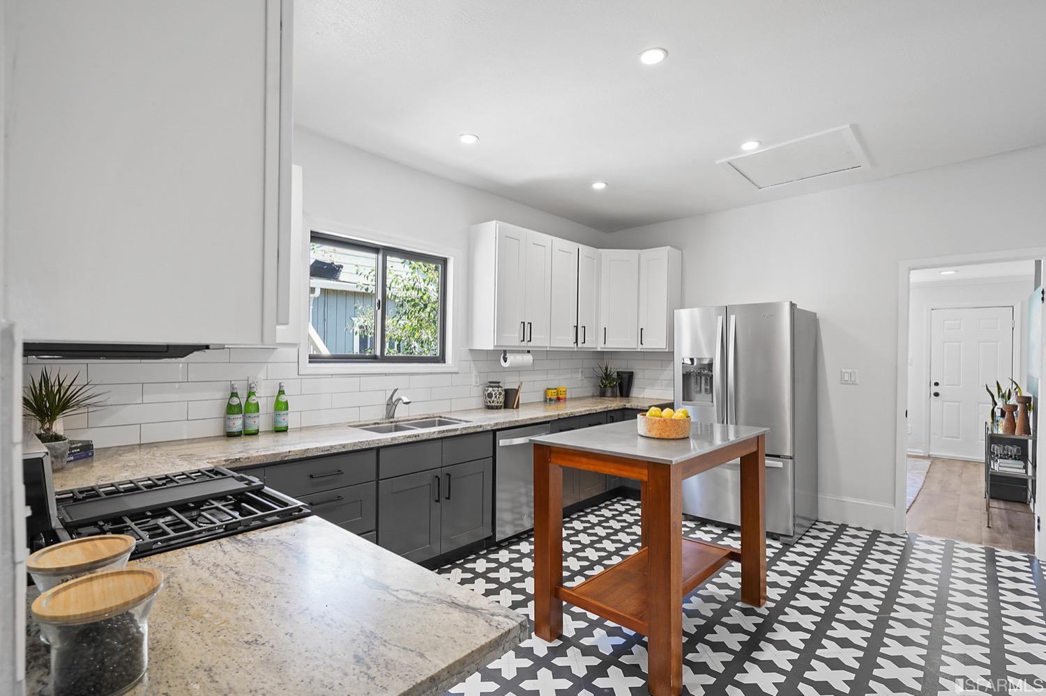1015 26th Street Oakland, CA 94607 - Photo 10 of 33 a kitchen with stainless steel appliances kitchen island granite countertop a sink stove and refrigerator