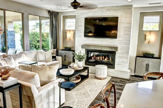 a living room with furniture a flat screen tv and a fireplace