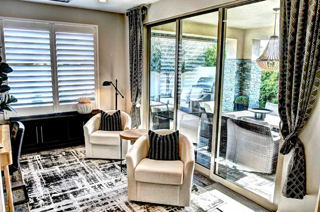 a living room with patio furniture and a floor to ceiling window