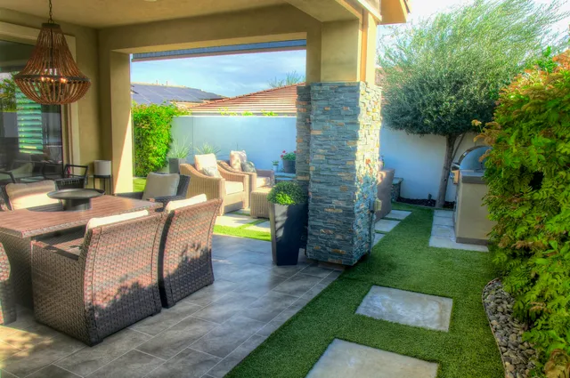 a view of a patio with table and chairs potted plants and a large tree