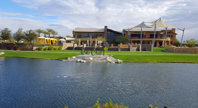 a view of a big house with a yard and a fountain
