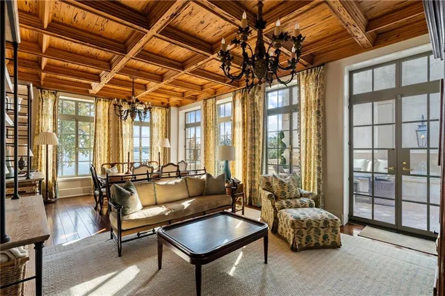 a dining room with furniture a chandelier and wooden floor