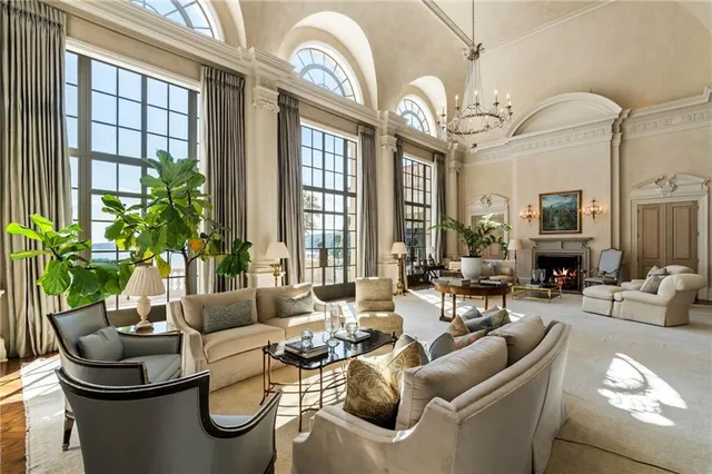 a living room with furniture fireplace and a large window