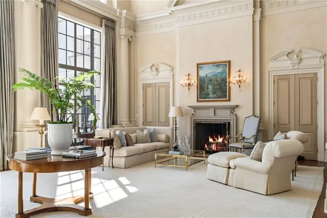 a living room with furniture a fireplace and a chandelier