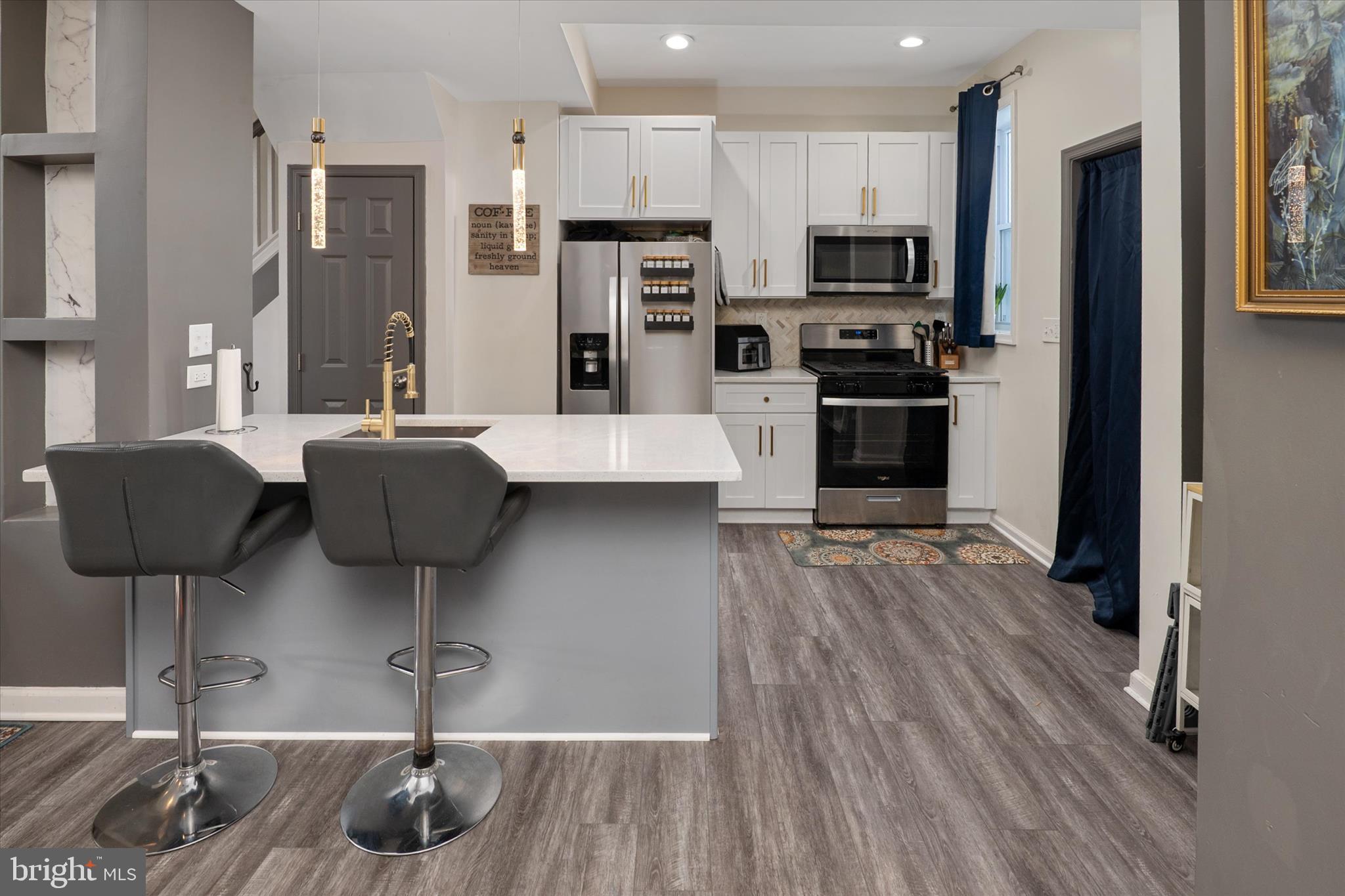 3714 5th Street Baltimore, MD 21225 - Photo 11 of 35 a kitchen with stainless steel appliances granite countertop a refrigerator a stove and a wooden floors