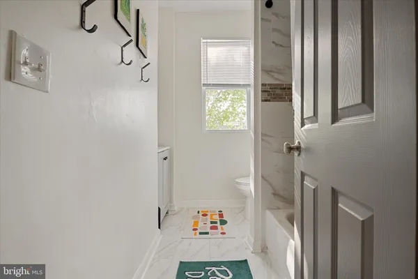 a walk in closet with wooden floor