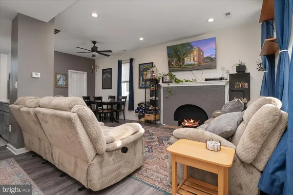 a living room with furniture a flat screen tv and a fireplace