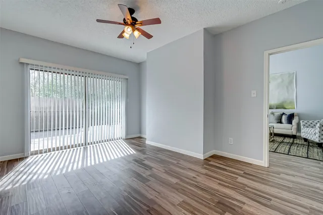 a view of a livingroom with wooden floor and a ceiling fan