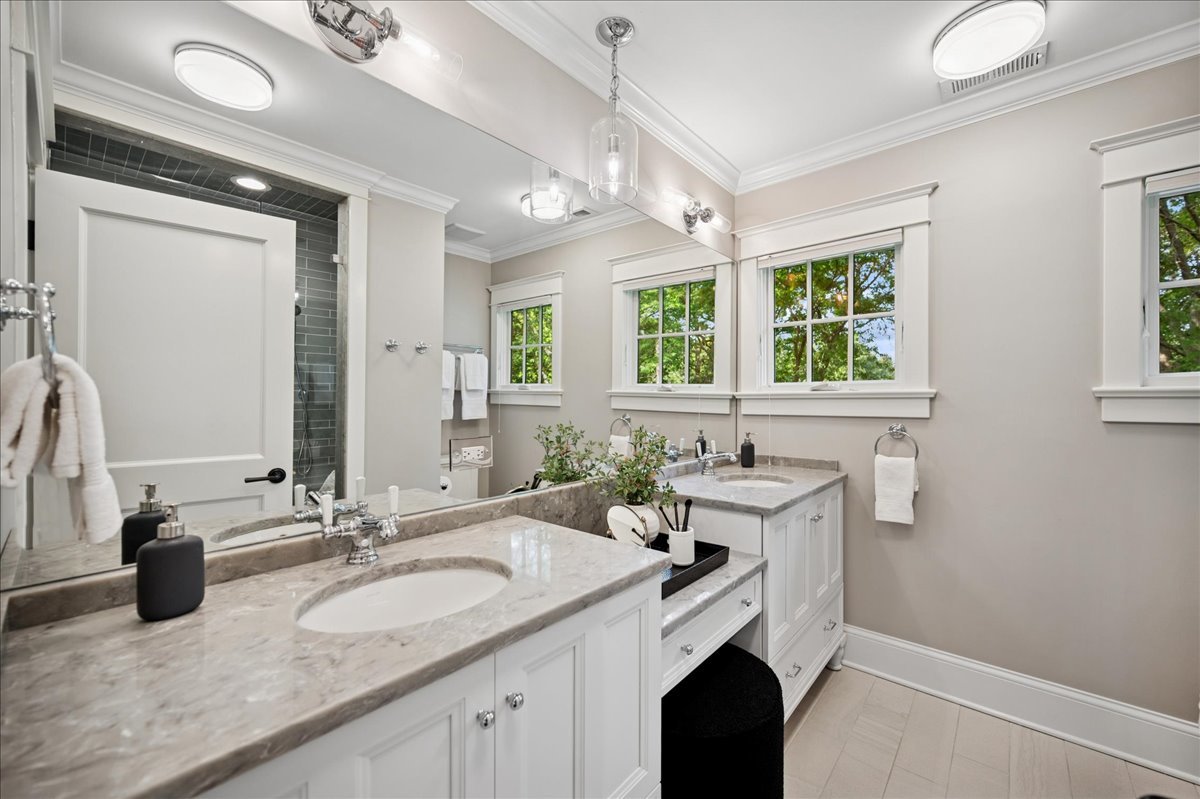 519 Cedar Street Winnetka, IL 60093 - Photo 22 of 36 a bathroom with a granite countertop sink a large mirror and a window