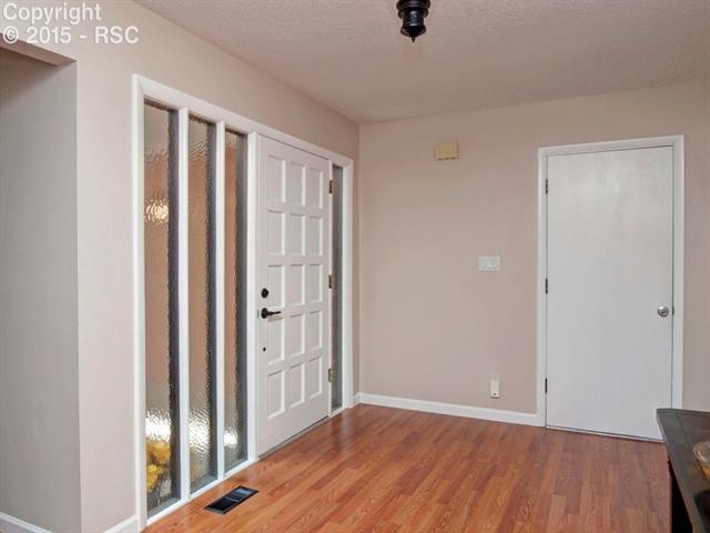 Open entry way with wood flooring and private beveled glass for privacy