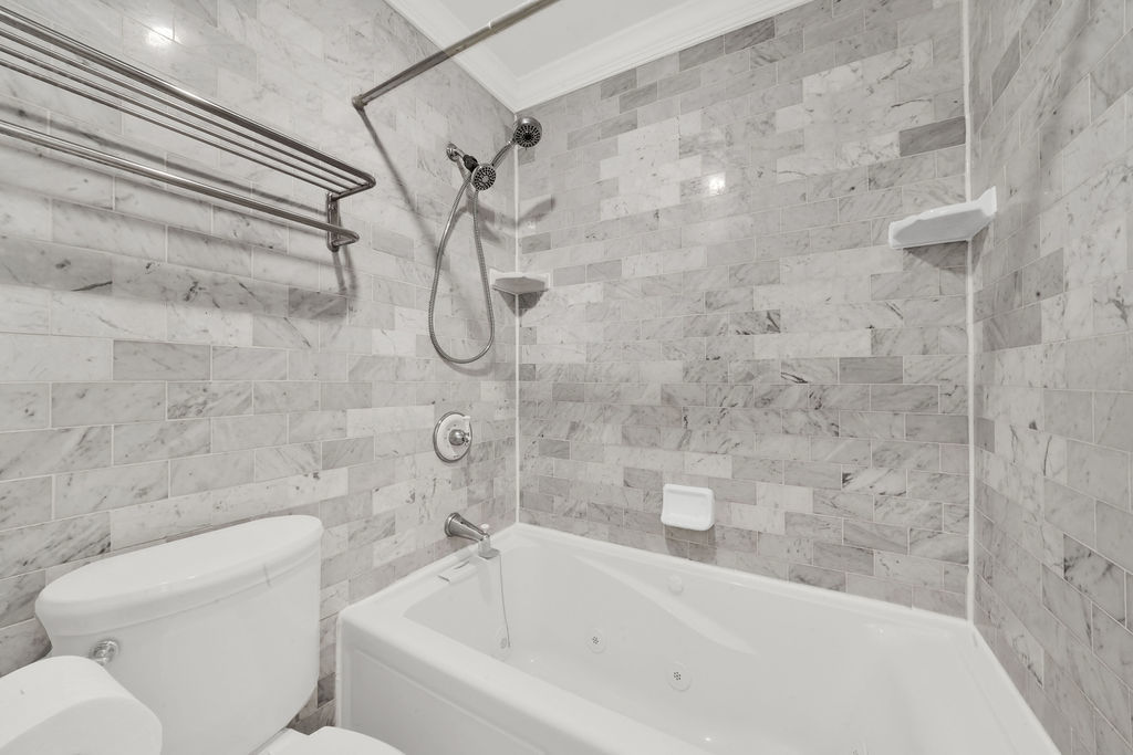 100 East Walton Street, Unit 17C Chicago, IL 60611 - Photo 11 of 21 a bathroom with a bathtub and a toilet