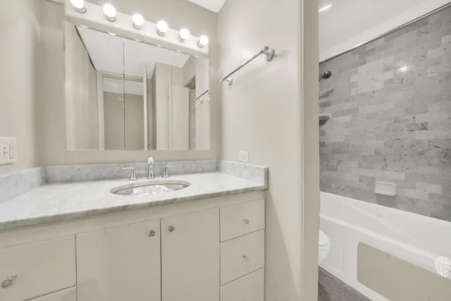a bathroom with a granite countertop sink and a mirror