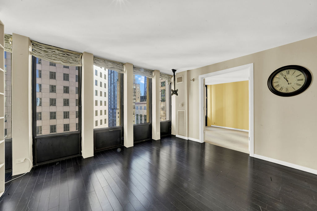 100 East Walton Street, Unit 17C Chicago, IL 60611 - Photo 8 of 21 wooden floor in an empty room with a window