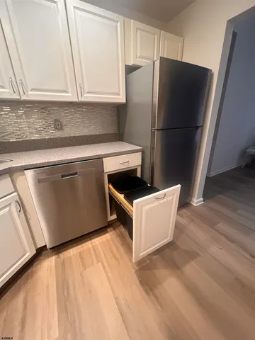 a kitchen with granite countertop a refrigerator and a sink