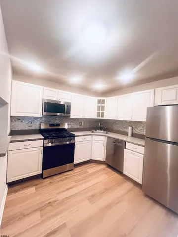 a kitchen with a refrigerator and a stove top oven