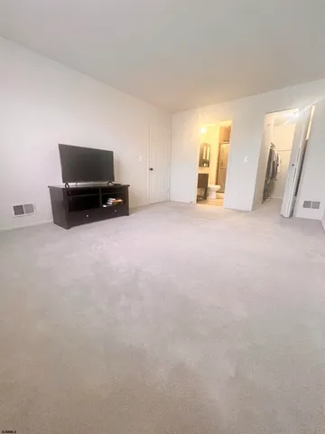 a view of an empty room and kitchen