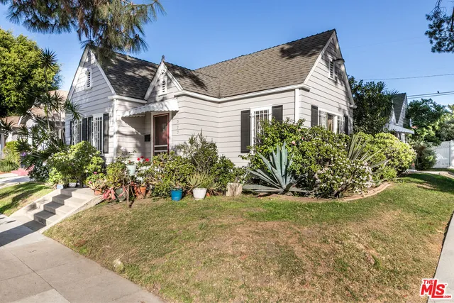 a view of a white house with a flower garden