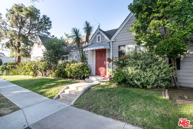 a front view of a house with a yard and trees