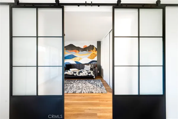 a bedroom with a bed and a flat tv screen next to a window