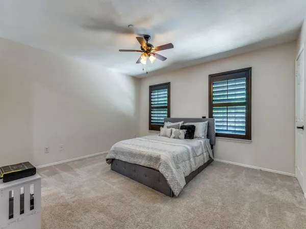 a bedroom with a bed and a ceiling fan