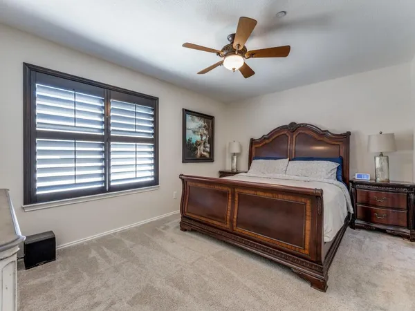 a bedroom with a bed a window and a chandelier