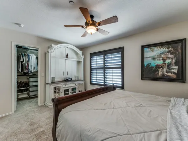 a bedroom with a large bed and a ceiling fan