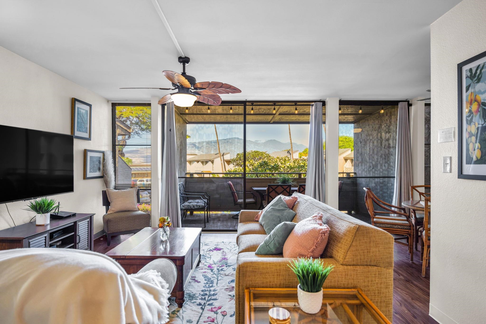 483 South Kihei Road, Unit 215 Kihei, HI 96753 - Photo 10 of 49 a living room with furniture a flat screen tv and a large window