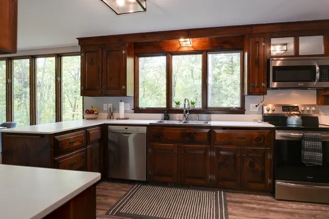 a kitchen with a sink a stove cabinets and a wooden floor