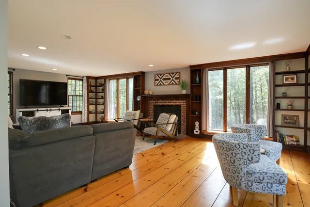 a living room with furniture a flat screen tv and a fireplace