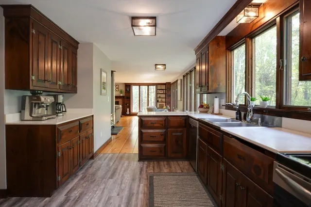 a kitchen with kitchen island granite countertop a sink appliances cabinets and a large window