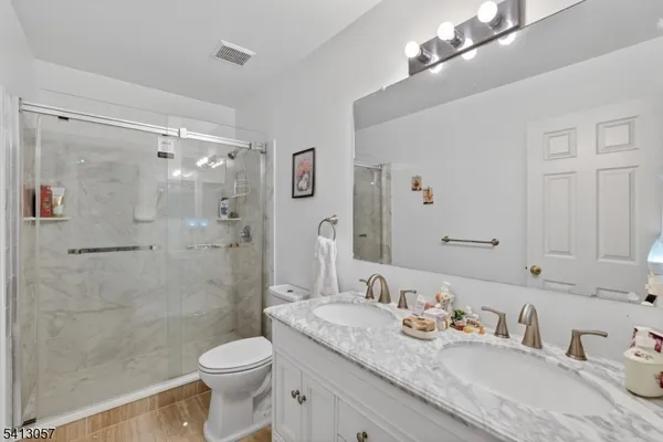 a bathroom with a granite countertop sink toilet and shower