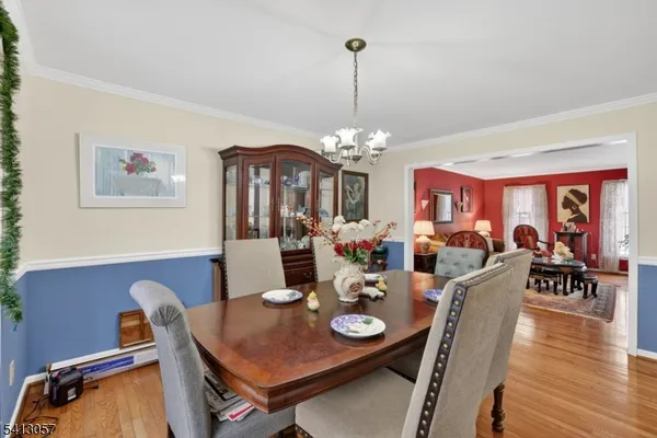 a view of a dining room with furniture wooden floor and chandelier