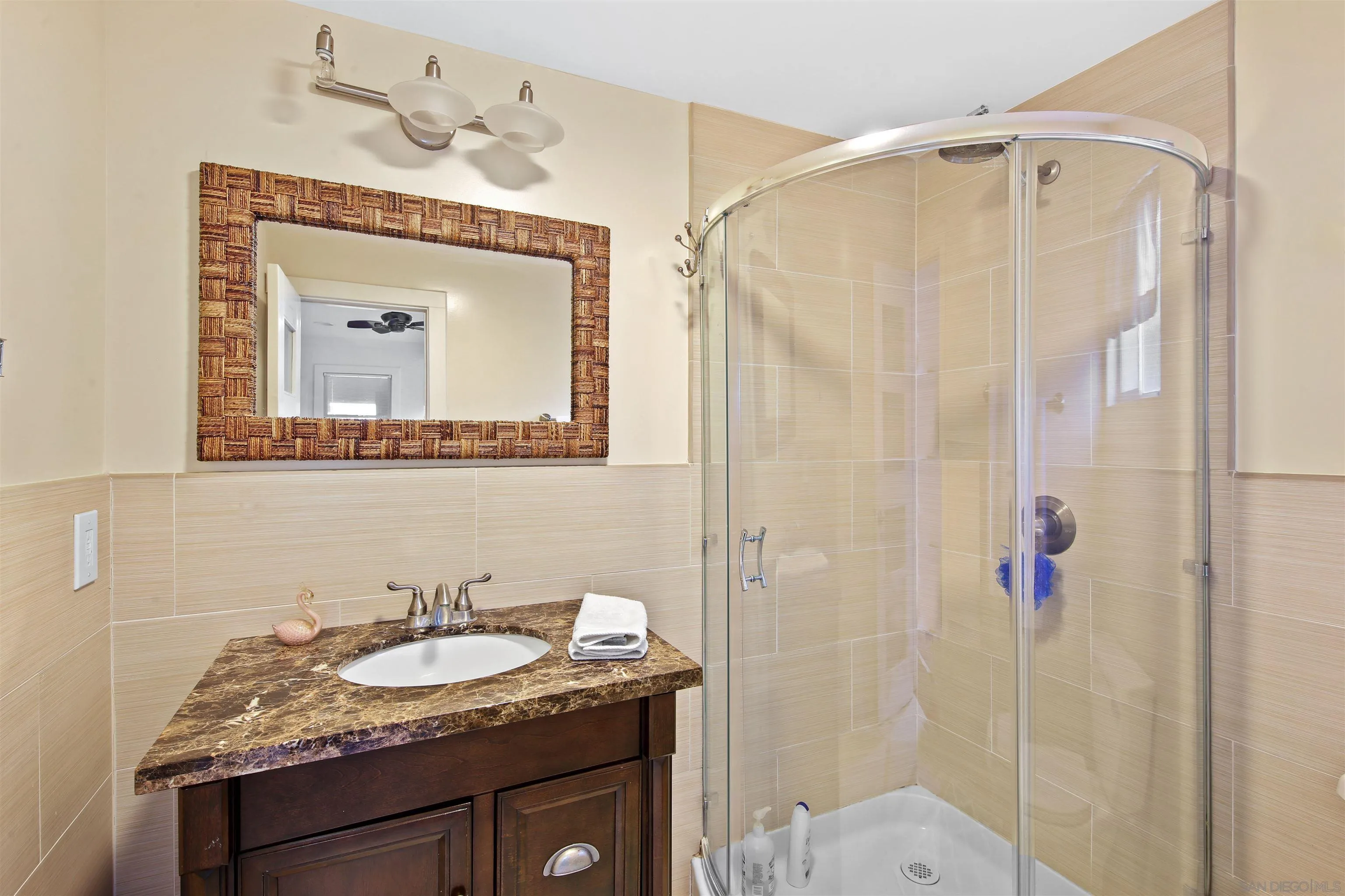 671 B Avenue Coronado, CA 92118 - Photo 27 of 41 a bathroom with a granite countertop sink a mirror and shower