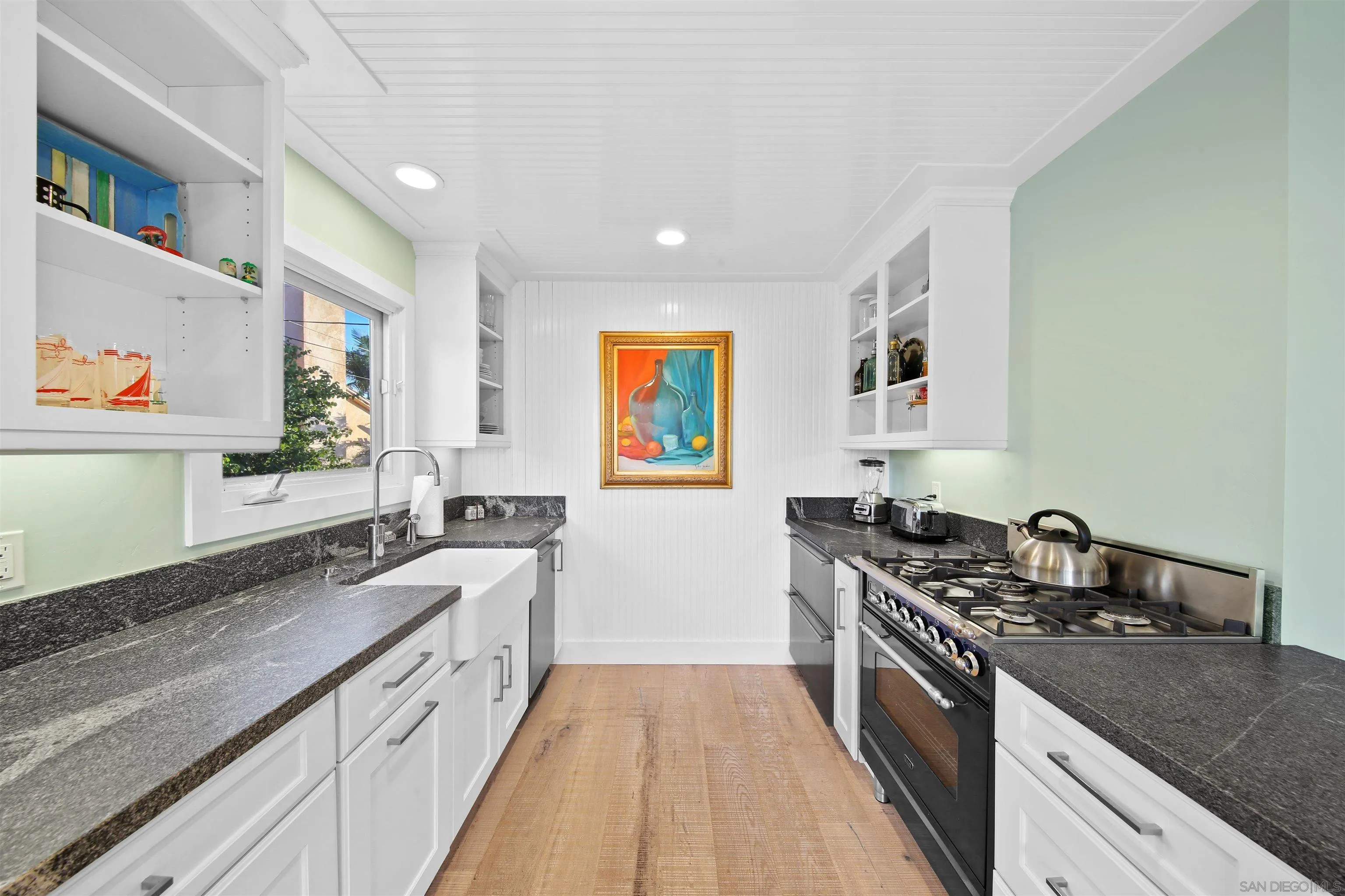 671 B Avenue Coronado, CA 92118 - Photo 30 of 41 a kitchen with granite countertop stainless steel appliances a sink a stove top oven a counter space and cabinets