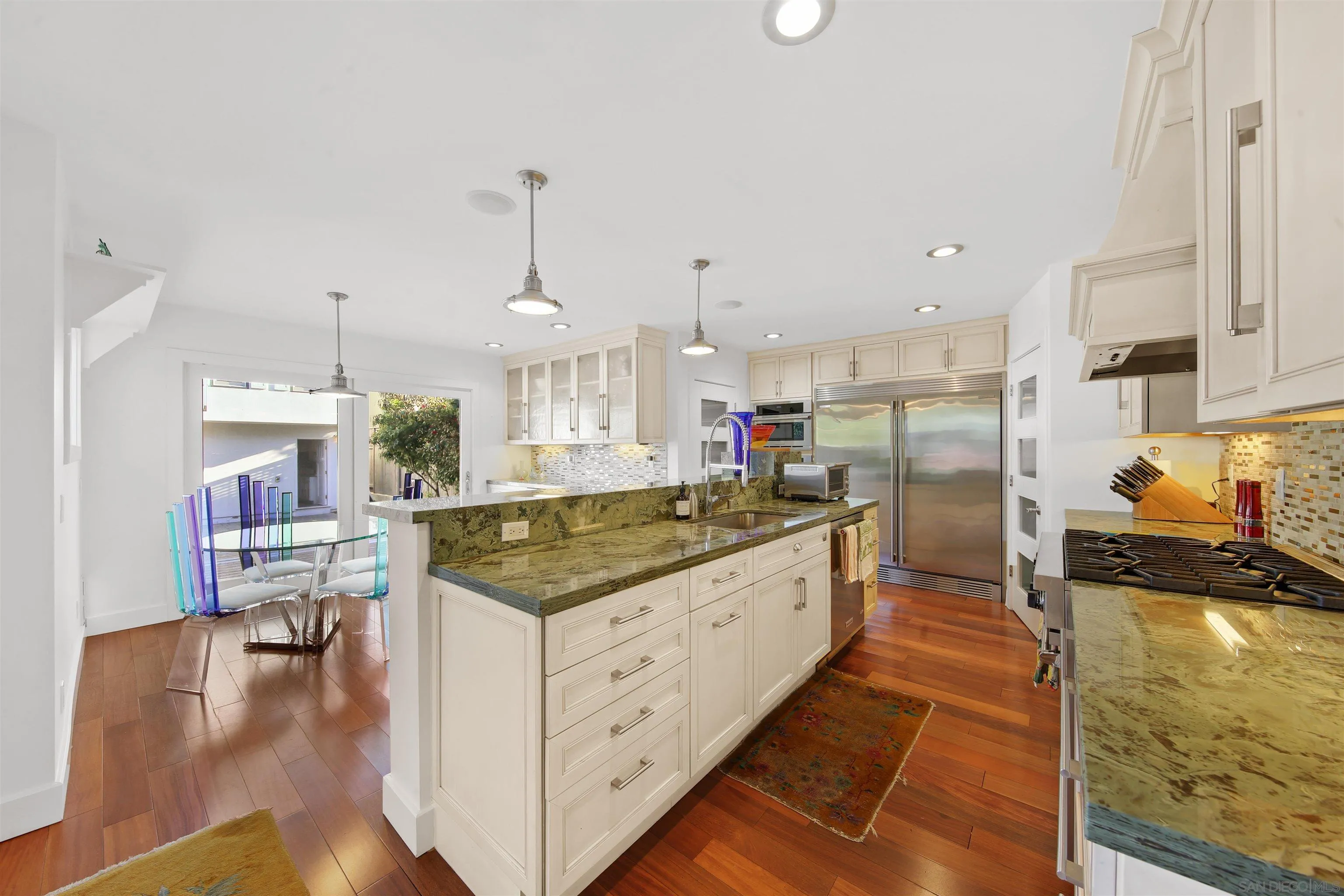 671 B Avenue Coronado, CA 92118 - Photo 6 of 41 a kitchen with granite countertop a stove a sink a refrigerator and white cabinets with wooden floor