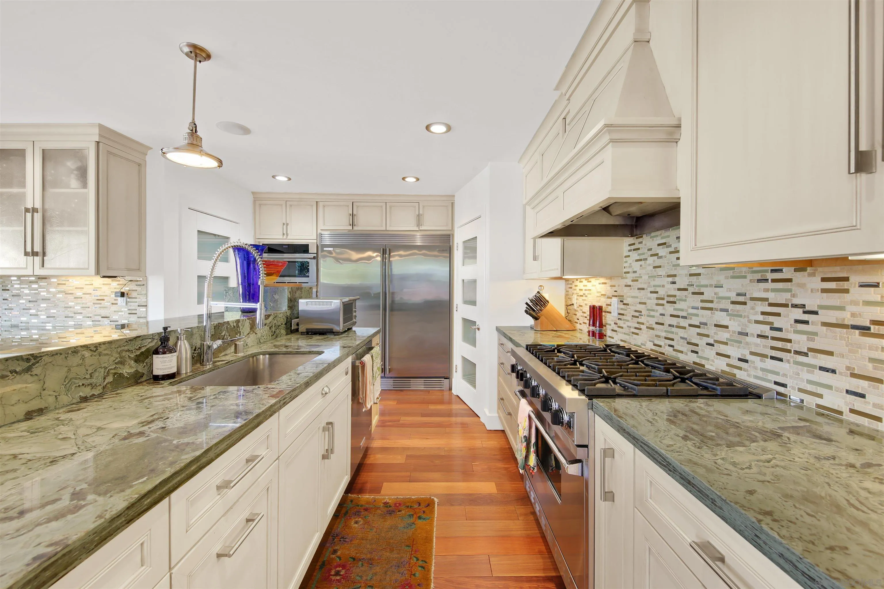 671 B Avenue Coronado, CA 92118 - Photo 8 of 41 a kitchen with granite countertop a sink and a stove