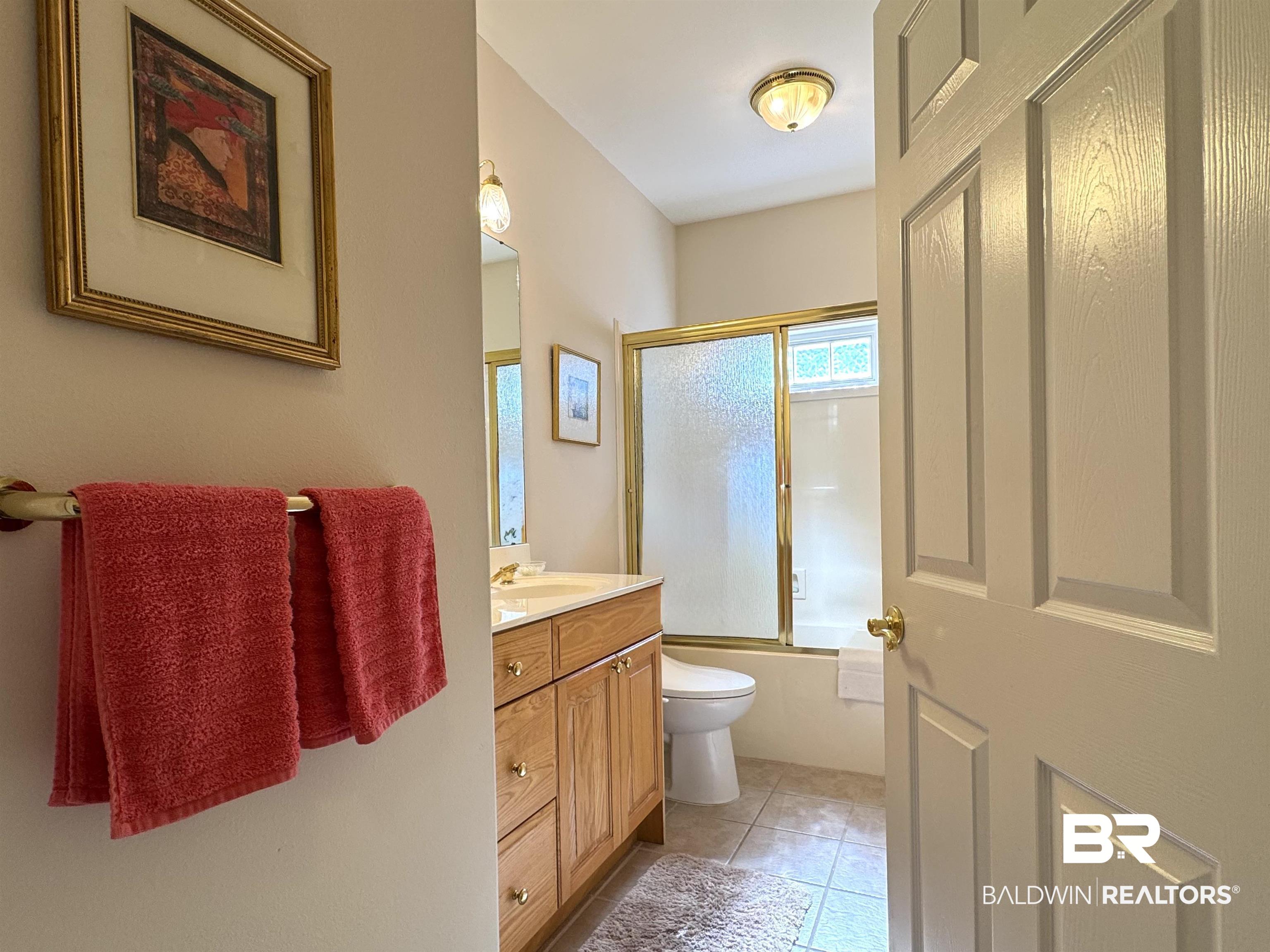 22415 Inverness Way Foley, AL 36535 - Photo 20 of 34 Full bathroom with combined bath / shower with glass door, vanity, tile patterned flooring, and toilet