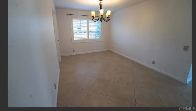 an empty room with windows and chandelier