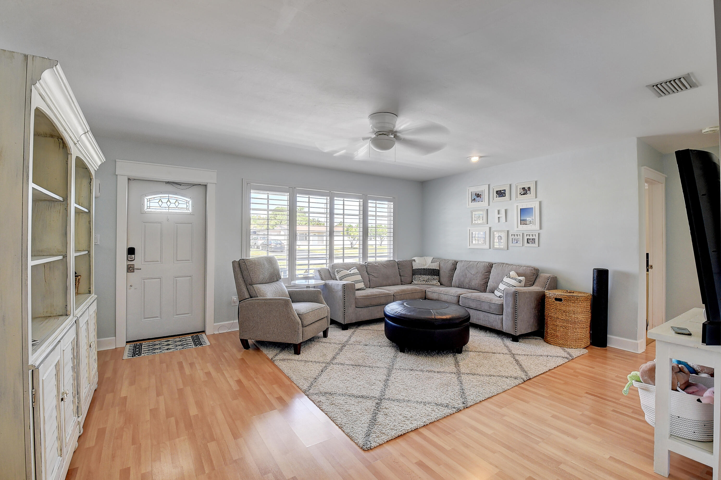 125 Riley Avenue Palm Springs, FL 33461 - Photo 2 of 24 a living room with furniture a flat screen tv and a window