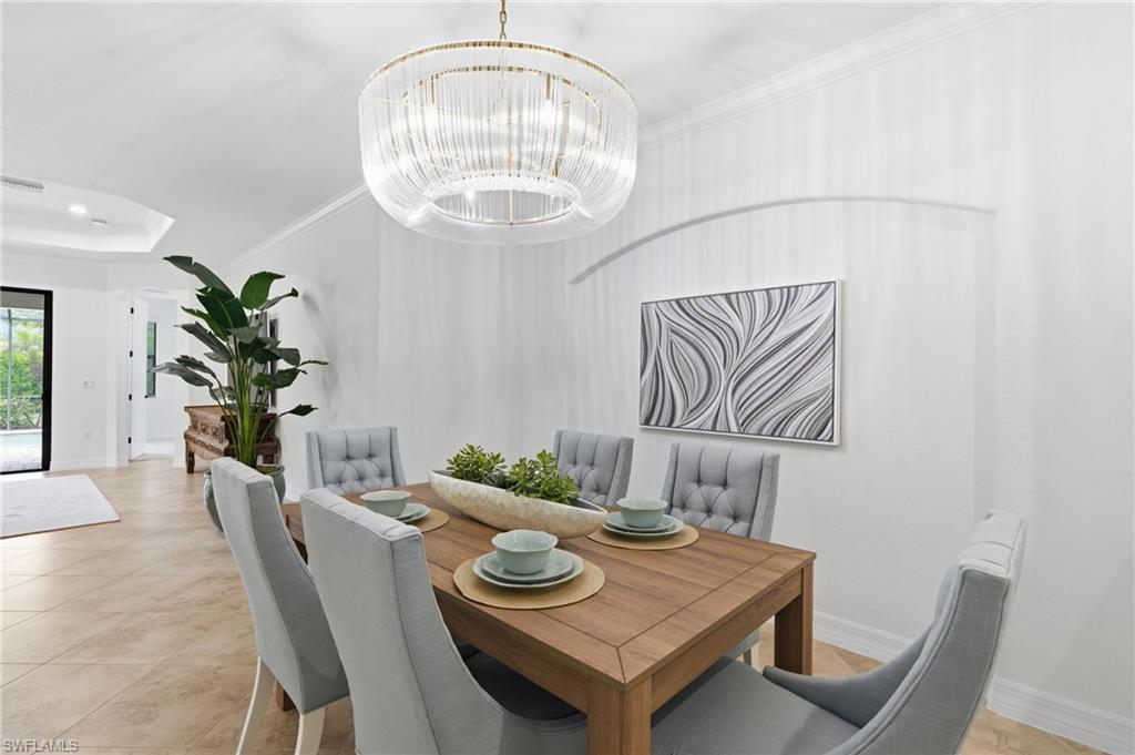 9479 Piacere Way Naples, FL 34113 - Photo 13 of 48 Dining area featuring a contemporary chandelier, recessed wall niche, crown molding, and neutral tile flooring