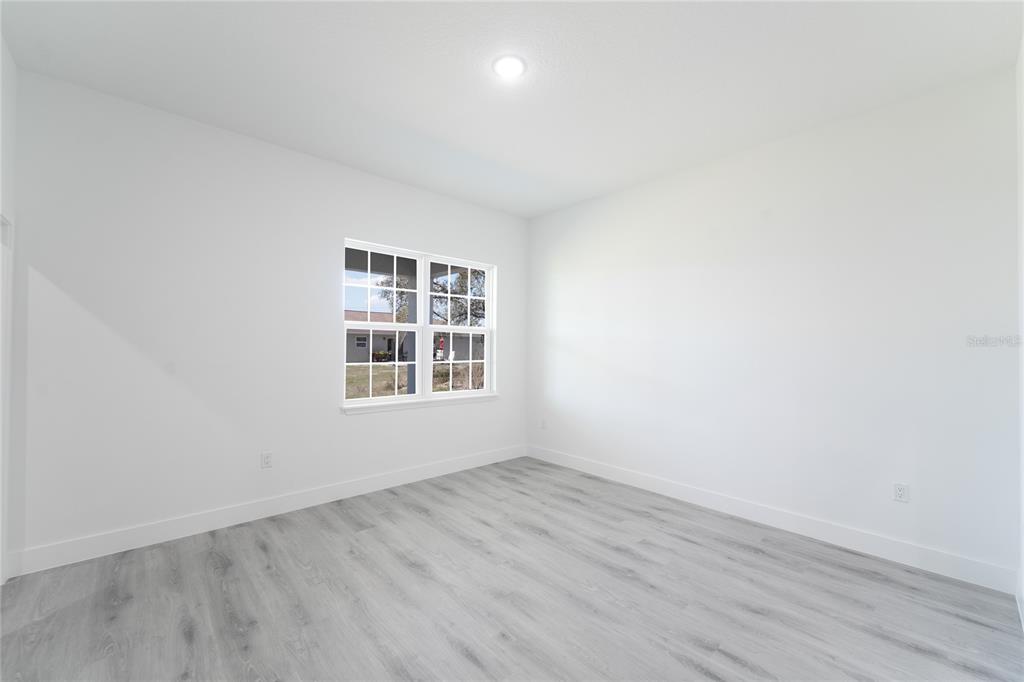 2600 Southwest 146th Pl Road Ocala, FL 34473 - Photo 22 of 40 an empty room with wooden floor and windows